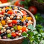 Bowl of colorful three bean salad with kidney beans, chickpeas, green beans, and a tangy vinaigrette